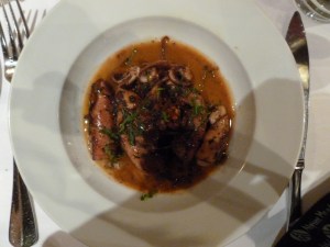 Calamari in red pepper sauce. Fragrance of lemons, strong lemon flavor mixed with red (bell, not hot) pepper and tender calamari. Very good.