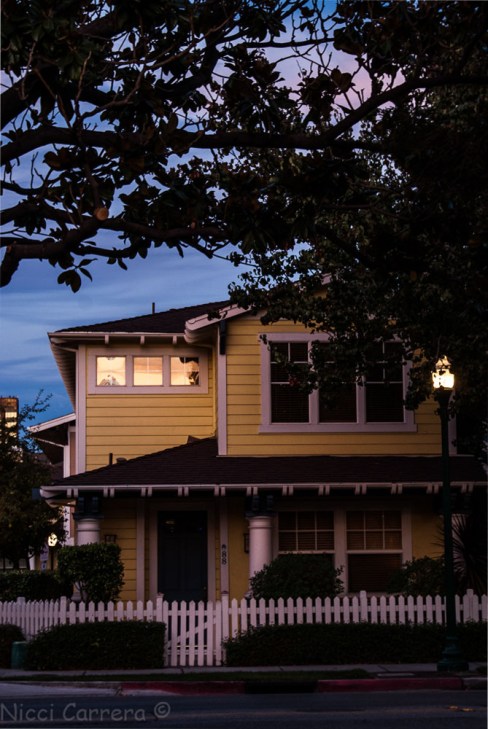 Yellow house at twilight windows reflecting the sunset